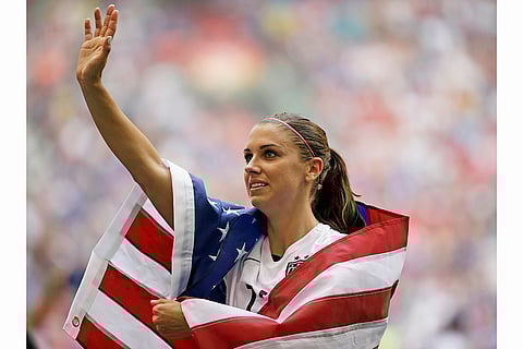 Alex Morgan Retires: United States' Alex Morgan is draped in the U.S. flag as she waves to fans after the U.S. beat Japan 5-2 in 2015 FIFA Women's World Cup